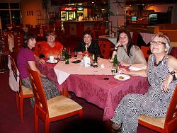 Nádherná ségra v rudé róbě v čele stolu, vlevo její kamarádka, vpravo její kamarádka, a moje dcera v šále a já